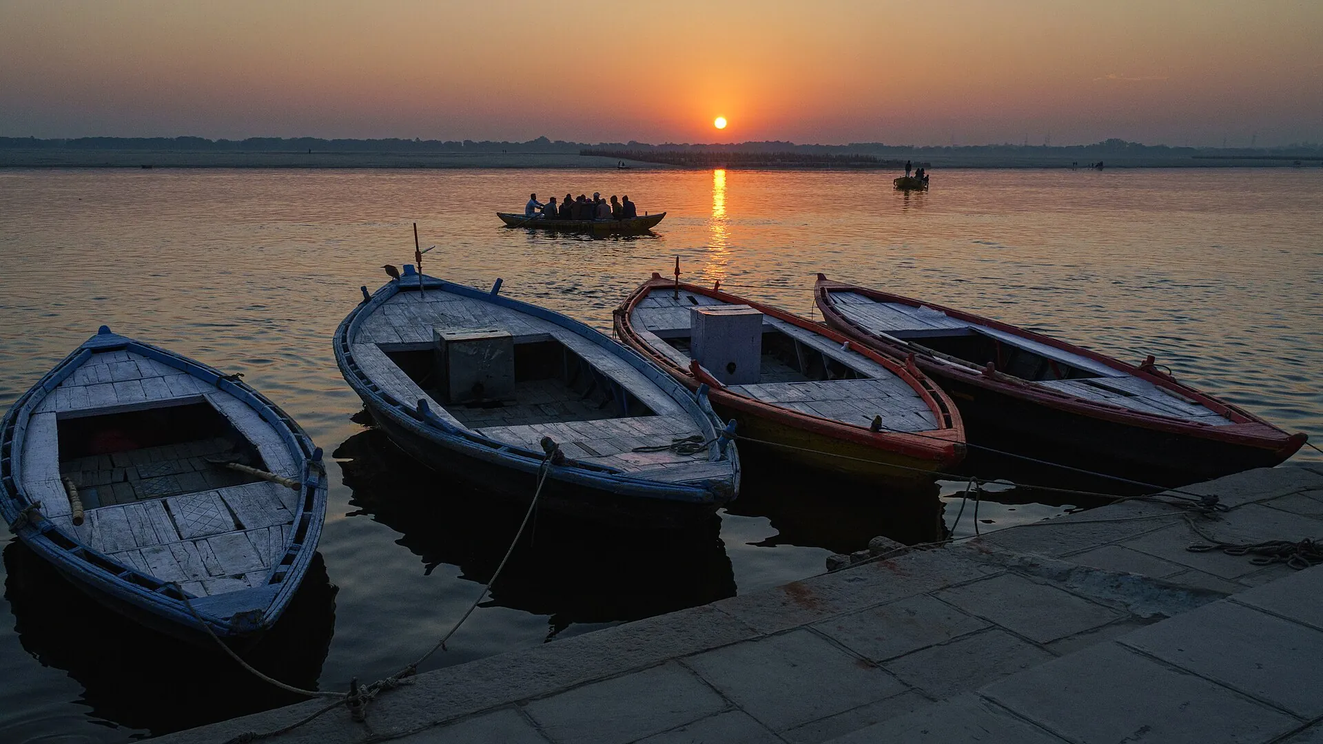 Sunrise over the Ganga with boats at the ghats of Varanasi